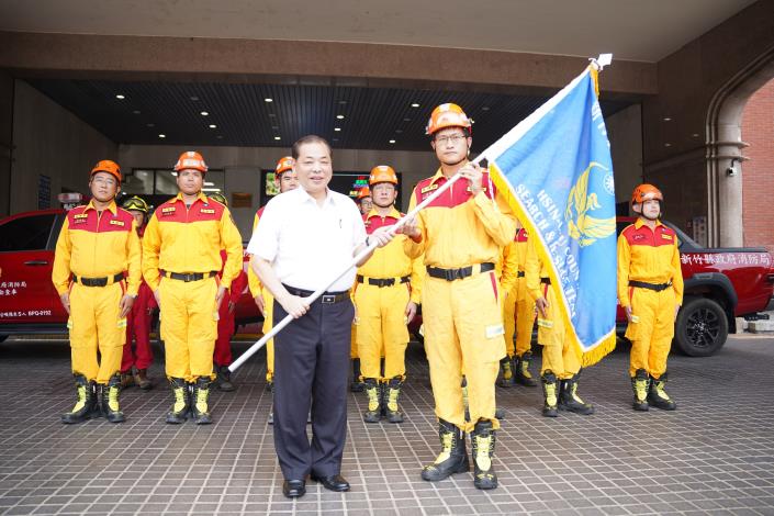 官網DSC09859副縣長陳見賢(左)授旗給新竹縣消防局支援花蓮的第二波警消，並叮嚀他們要注意自身安全。.JPG
