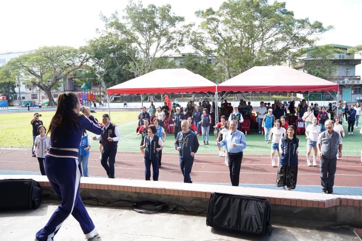 官網-活動開場前，主持人邀請現場貴賓一起做健康操。 的圖片