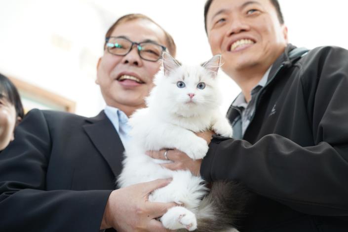 官網-副縣長陳見賢與認養人共同與貓咪合影。 的圖片