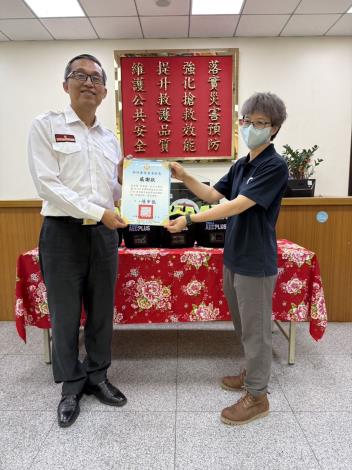 消防局副局長李立成致贈感謝狀，因捐贈人子女皆在國外，因此由由AED廠商代表接受。 的圖片